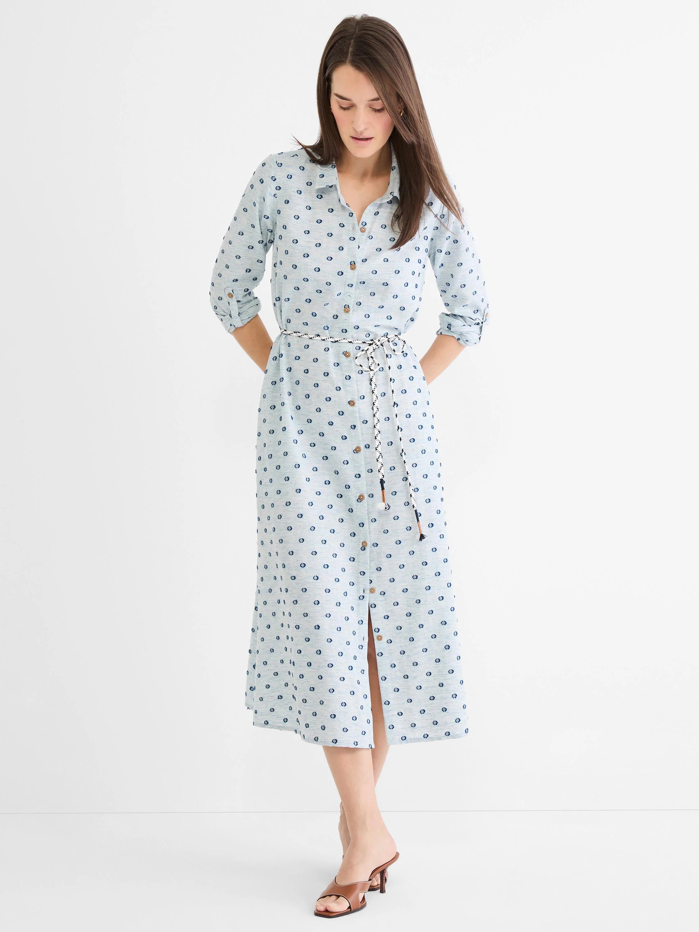 Light blue midi shirt dress with dark blue clipped dots, full button-front, brown buttons, and a braided black/white rope...