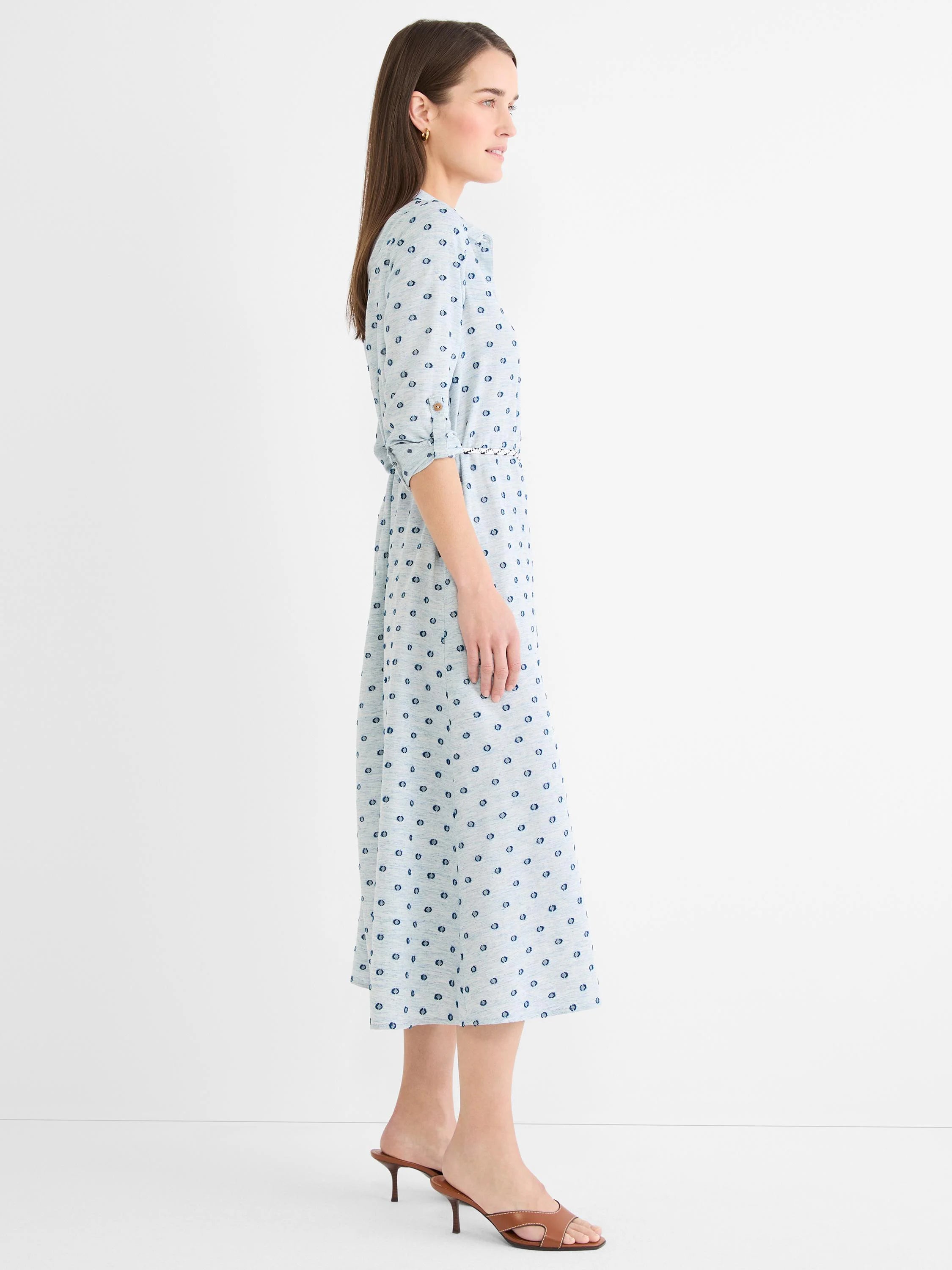 Light blue shirt dress with dark blue clipped dots, 3/4 rolled sleeves, self-tie belt, and midi length.