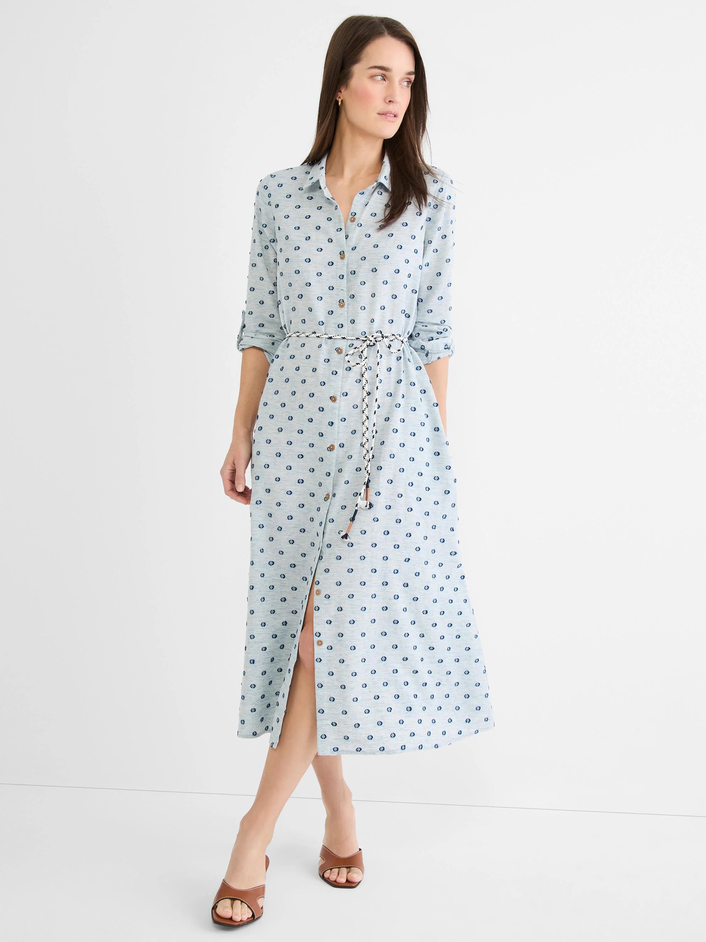 Pale blue midi shirt dress with dark blue clipped dots, button-front, braided belt, rolled sleeves, and front slit.