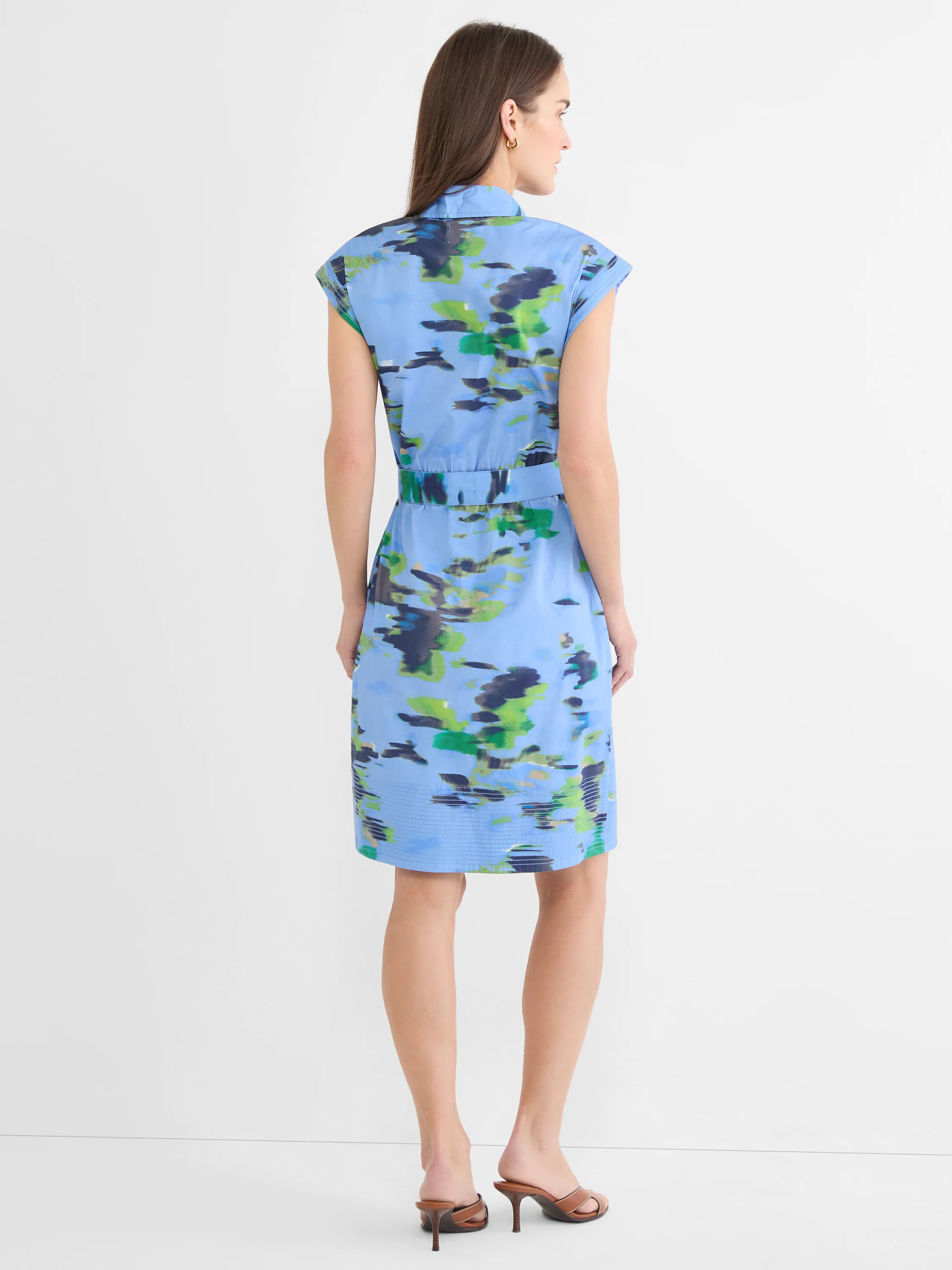 Back view: Light blue knee-length shirt dress with abstract green & navy water lily print, cap sleeves, belted waist.