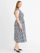 White midi dress with abstract dark blue and black lines, V-neck, cap sleeves, and an elastic waist.