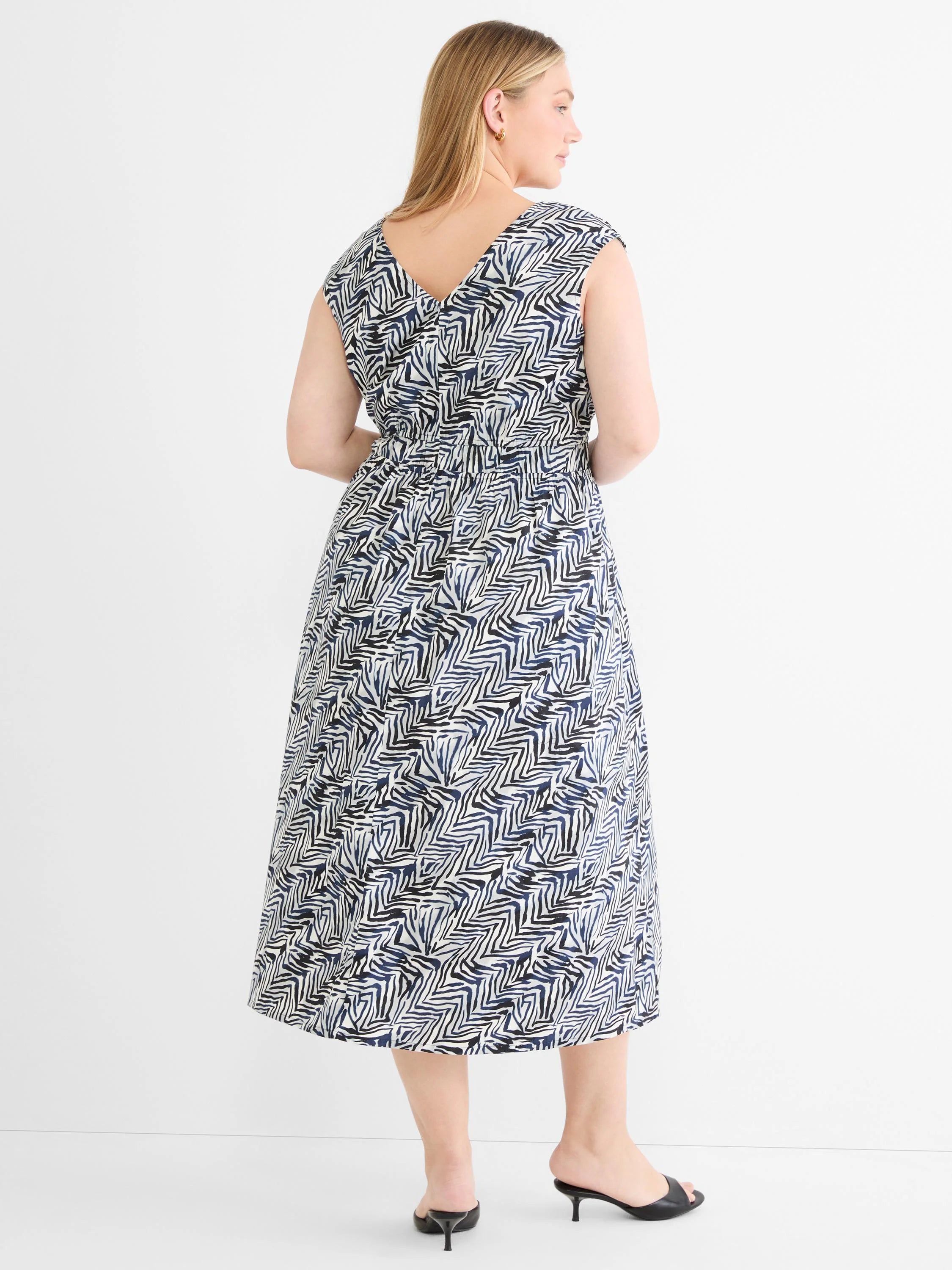 Midi dress with an abstract pattern of navy blue & black angular lines on off-white. V-neck back, cap sleeves, cinched waist.