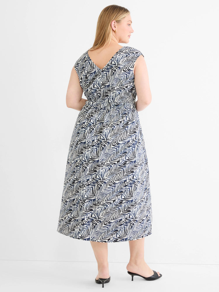 Midi dress with an abstract pattern of navy blue & black angular lines on off-white. V-neck back, cap sleeves, cinched waist.