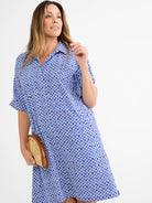 Blue shirt dress with collared V-neck and short sleeves. Features a mosaic pattern of small blue, white, black, and gold...