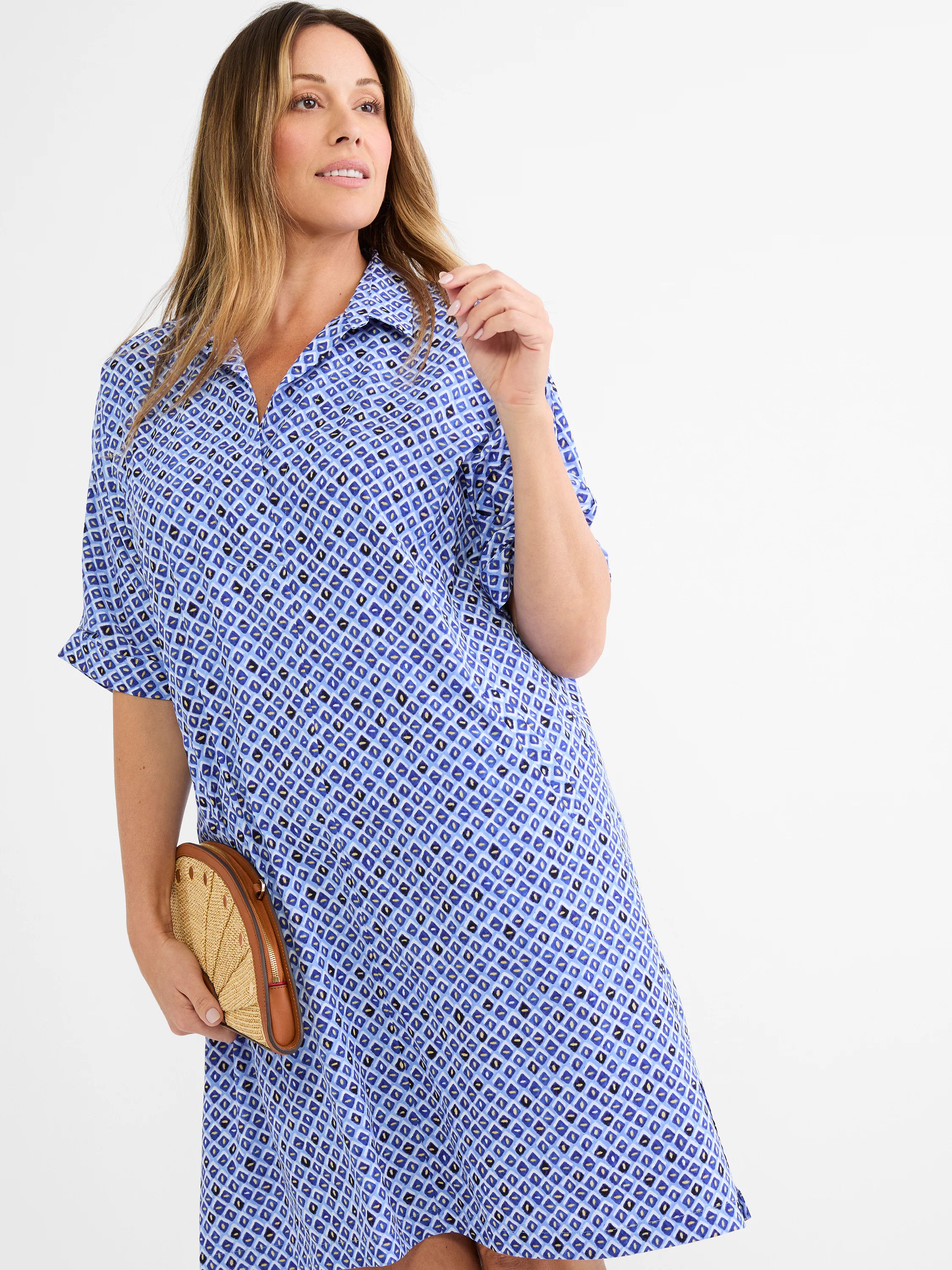 Blue shirt dress with collared V-neck and short sleeves. Features a mosaic pattern of small blue, white, black, and gold...
