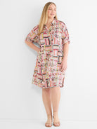 A relaxed multicolor geometric button-front shirtdress features cuffed short sleeves and hits above the knee.