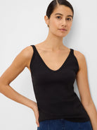 Black ribbed V-neck tank top with thin straps on a model.