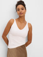 Light cream ribbed V-neck tank top on a model.
