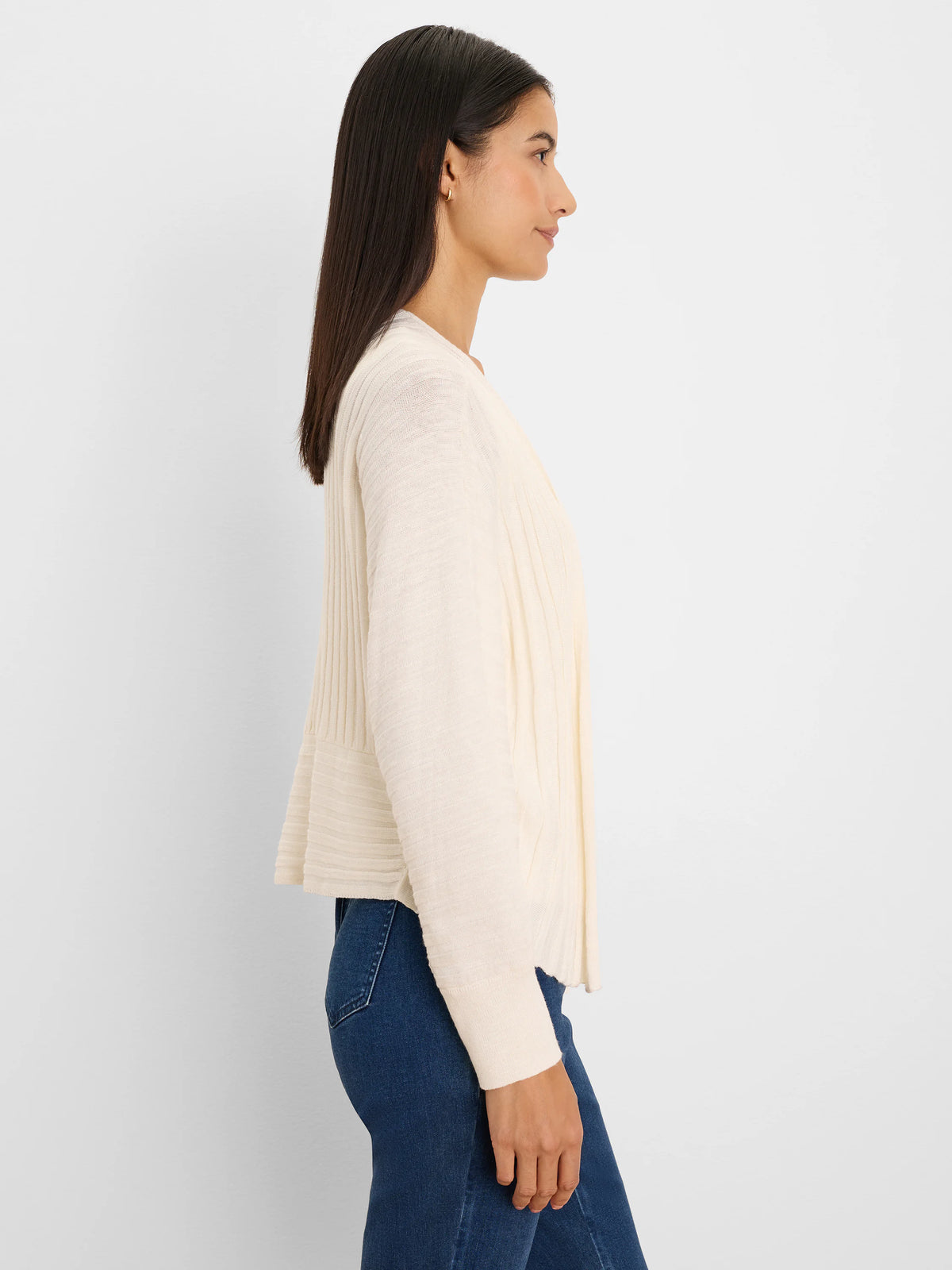 Off-white open cardigan with accordion vertical ribbing; model shown in profile.