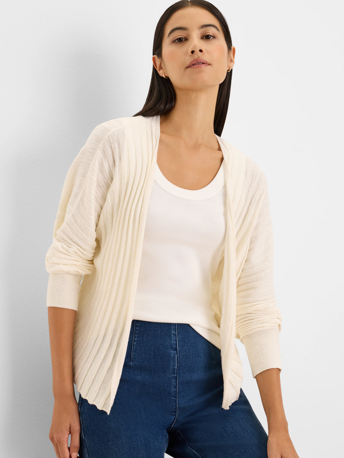 Cream open-front cardigan with vertical accordion ribbing.