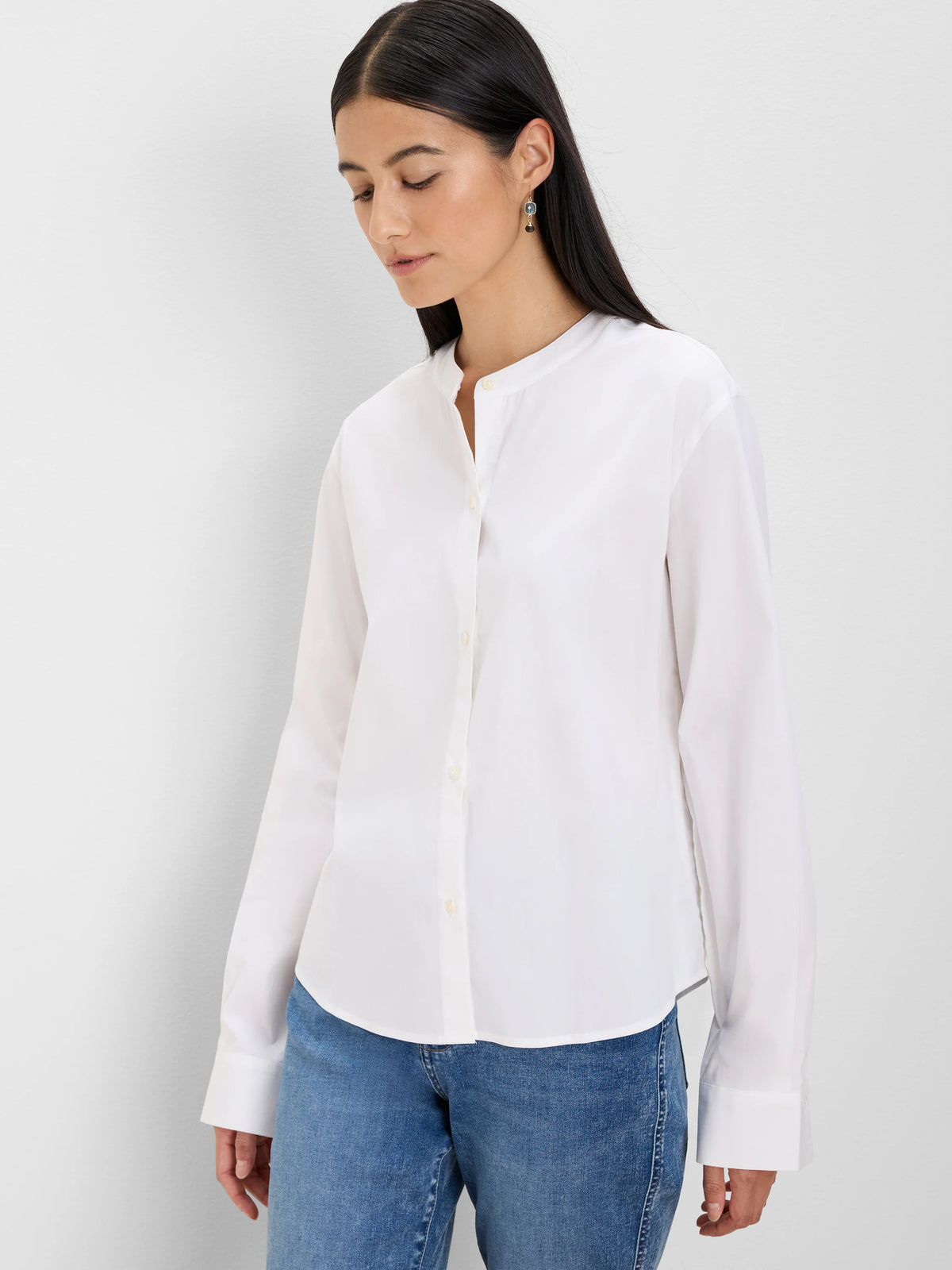 White cotton collarless shirt with a band collar, front buttons, and long sleeves with wide cuffs.