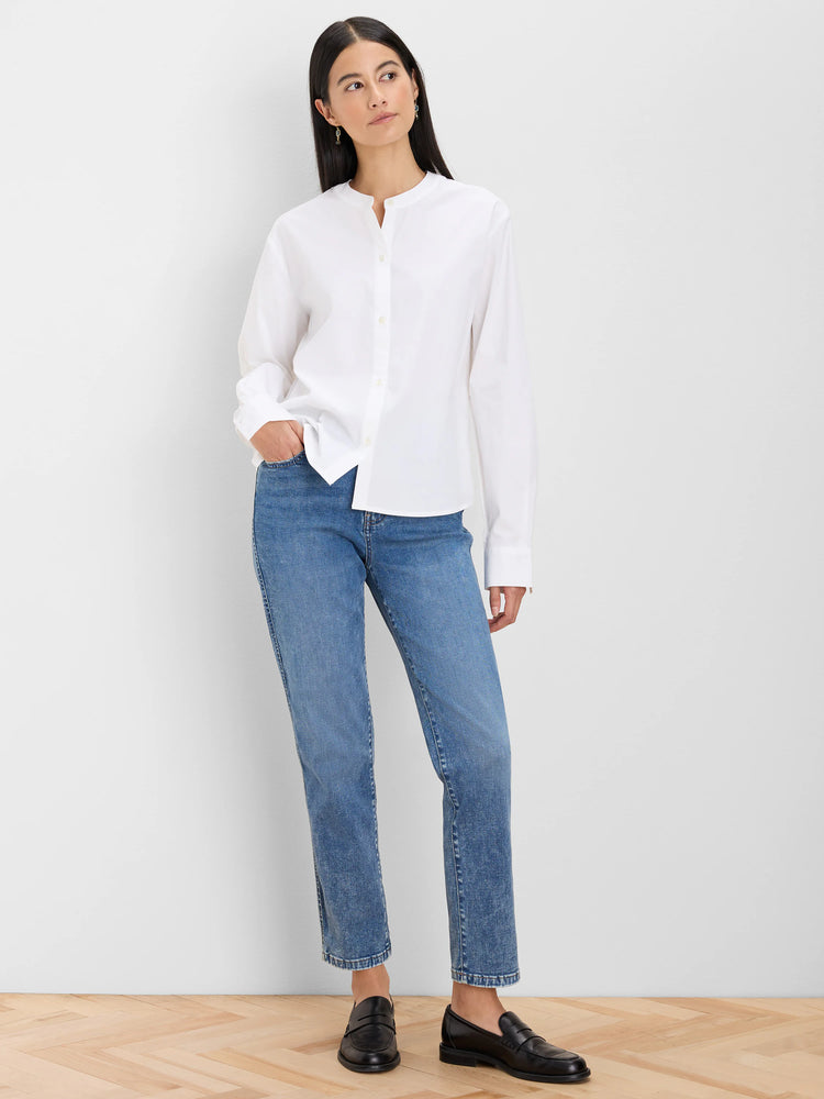 White collarless cotton shirt with a partial button placket and long sleeves on a model.