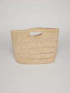 Beige woven handbag with a cutout top handle.  The bag is textured and slightly rectangular.