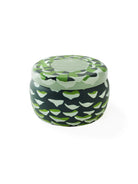 Soy candle in dark green tin with lighter green & white pine cone pattern.