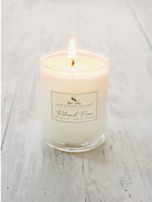 Lit ivory candle in clear glass jar.  Label shows dark-green text on cream background.