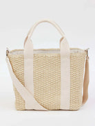 Off-white woven straw tote bag with cream-colored canvas straps and shoulder strap.