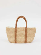 Beige woven handbag with darker beige braided handles and vertical accents.