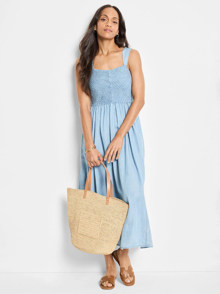 Beige, woven tote bag with tan leather handles and small front pocket.