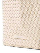 Off-white woven tote bag.  Close-up shows a tightly woven, textured pattern.  Brand label visible.