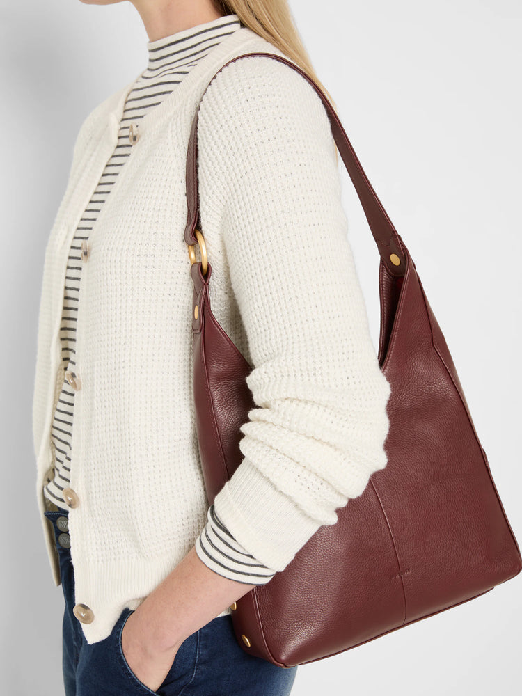 Medium burgundy pebbled leather bag with a slouchy shape, single strap, and gold-tone hardware.