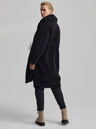 Black long-line teddy fleece coat with a high collar and drawstring waist.