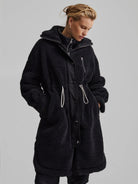 Black, long, textured fleece coat with layered collar & placket. Silver zippers, black snaps, and light grey drawstrings.