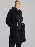 Black hooded longline sherpa coat with smooth center panel, dark buttons, zipper, and white drawstring details.