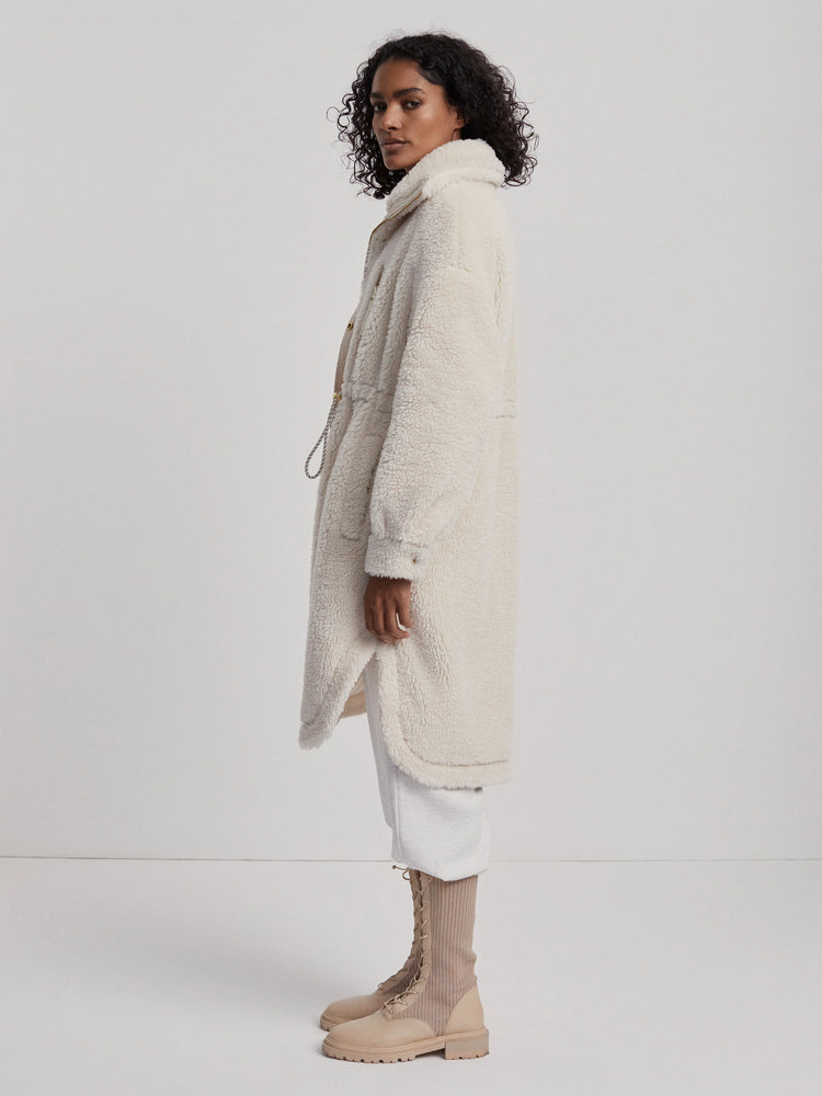 Cream, long fuzzy coat with a standing collar and side slits.