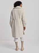 Off-white, long, collared, belted teddy-textured coat.  Side slits.