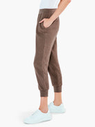 Brown ribbed sweatpants, cuffed at the ankle, with side pockets.