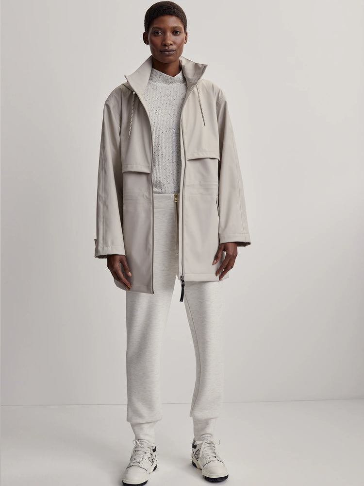 Varley Alyssa Raincoat: Pale taupe, mid-length, hooded, full-zip. Features waist drawstrings and chest flap pockets.