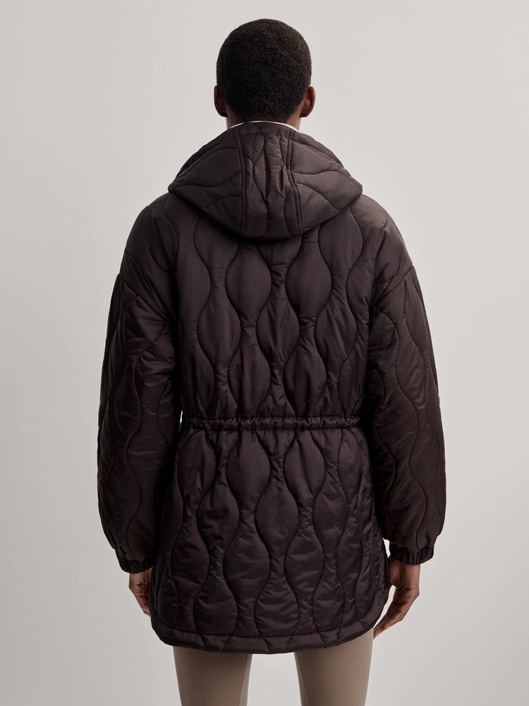 Dark brown hooded quilt jacket with wavy pattern and cinched drawstring waist, seen from back.