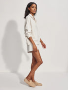 Oatmeal heather half-zip sweater with a collar, gold zipper, and relaxed fit.