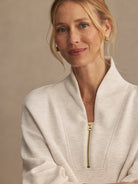 Pale beige marl sweatshirt with a high collar and gold front zipper.