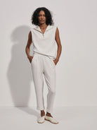Off-white rolled-cuff pants on a model.  The pants are a textured off-white fabric.