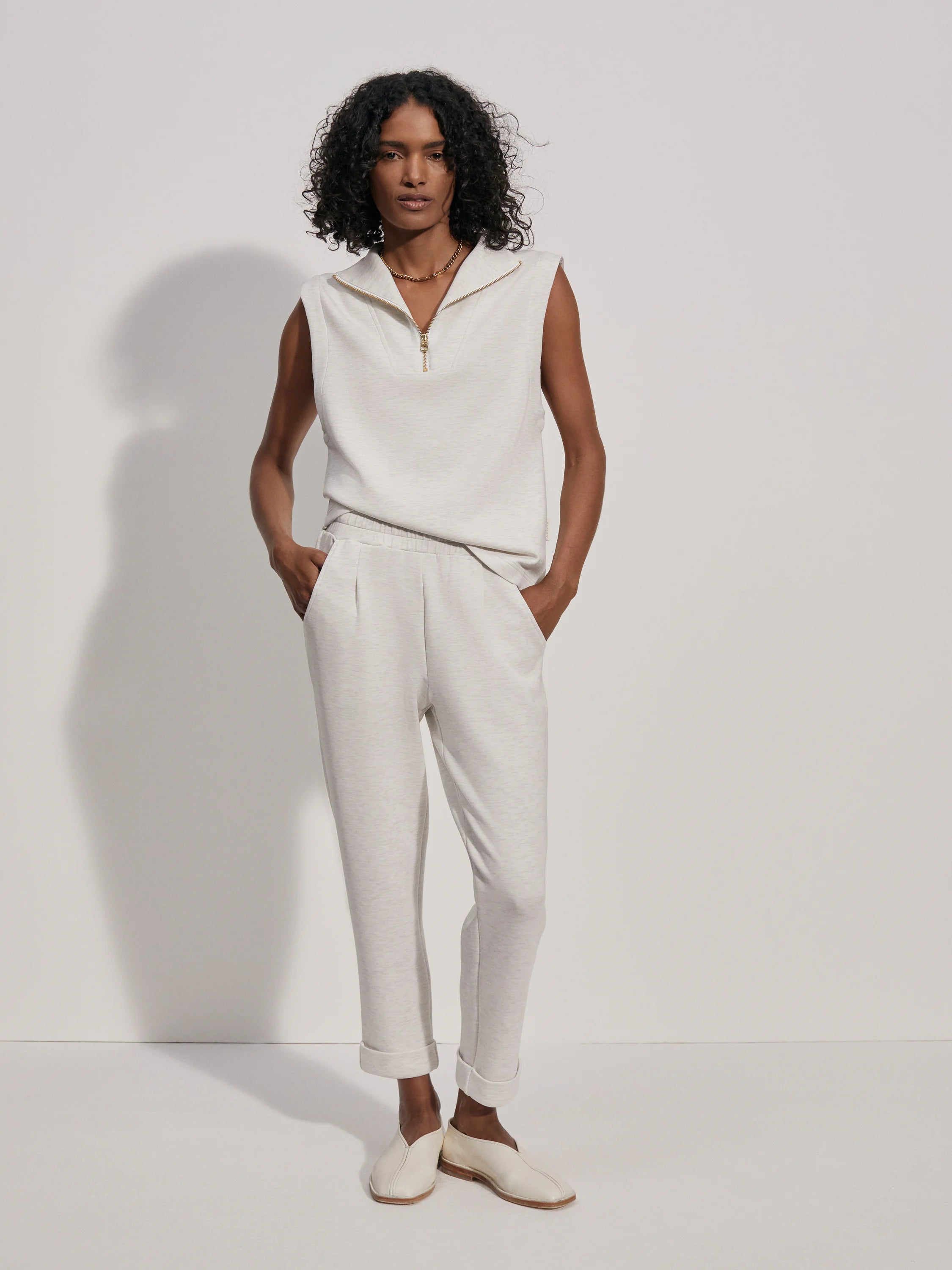 Off-white rolled-cuff pants on a model.  The pants are a textured off-white fabric.