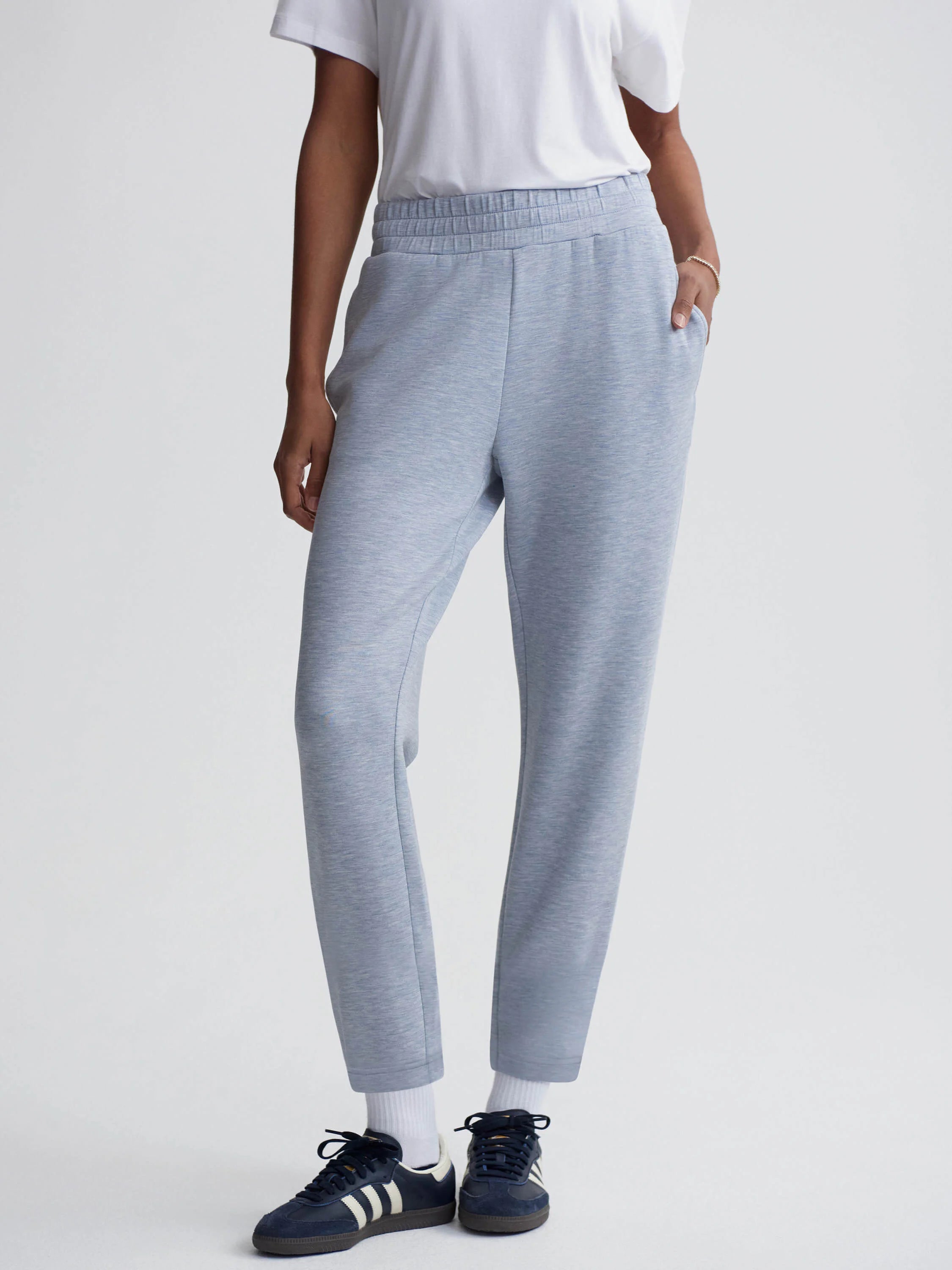 Light blue, slim-fit pants with an elastic waistband.  The pants have pockets.