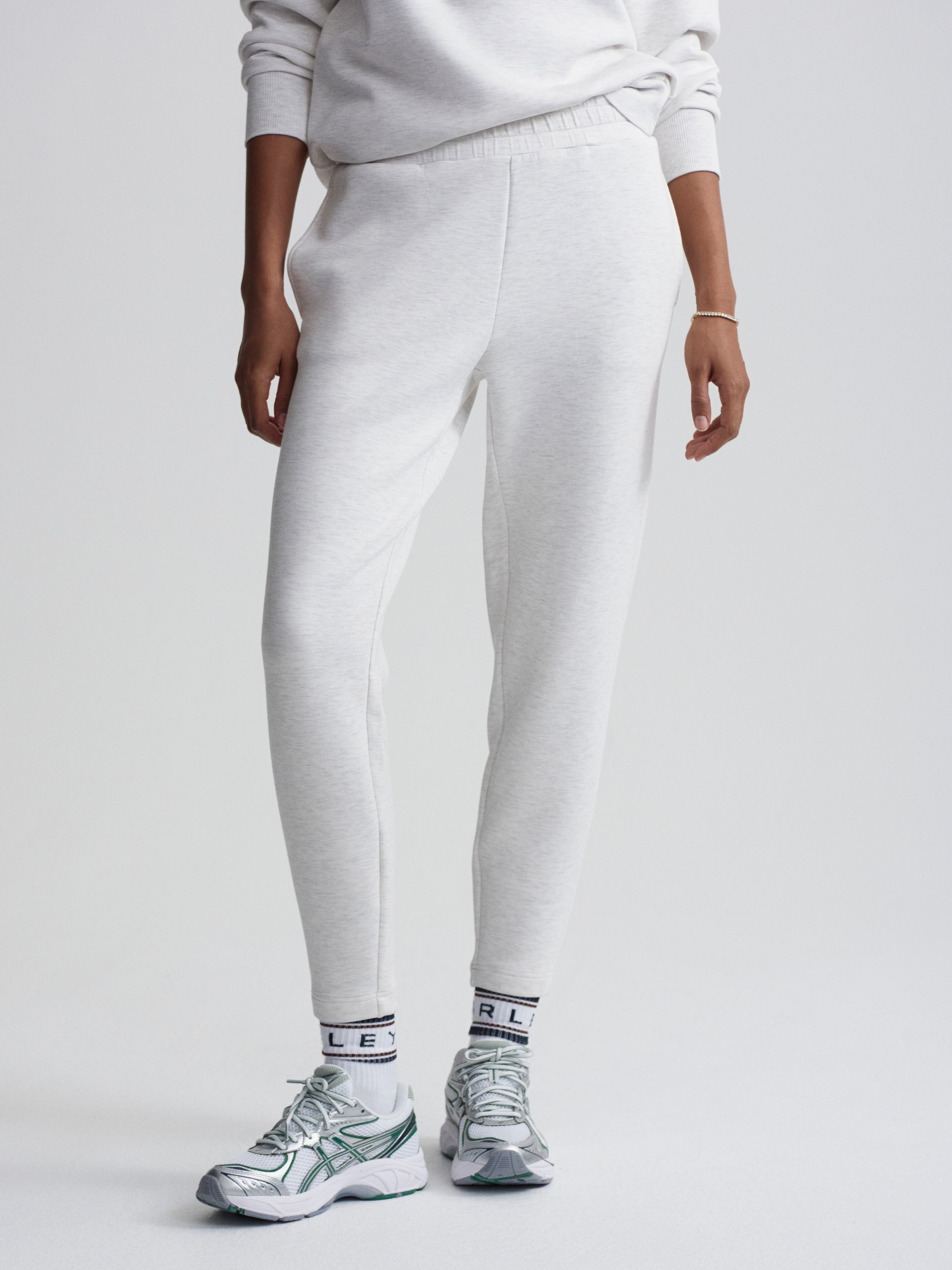 Light gray tapered knit sweatpants feature an elastic waist and a casual jogger silhouette.