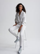 Model wears a relaxed heather grey quarter-zip pullover and tapered jogger sweatpants loungewear set.