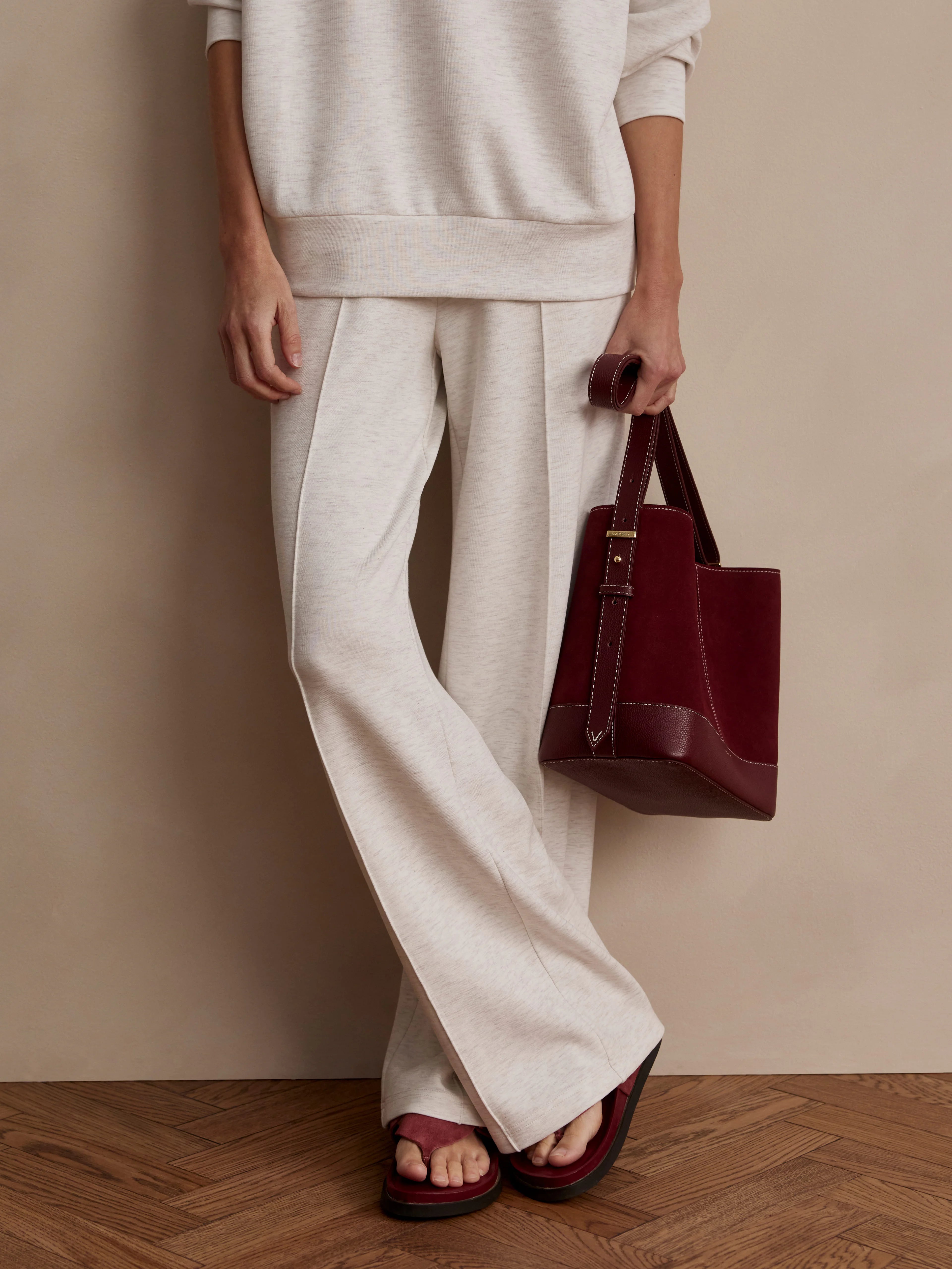 Oatmeal wide-leg knit pants with prominent front vertical seams, shown on a model.