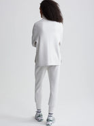 Light gray zip-through jacket, shown from the back.  The model also wears matching light gray joggers.
