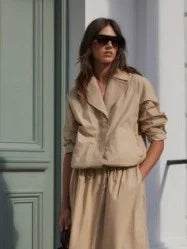 Beige boxy blouson jacket with a collar, short length, and cinched waist.