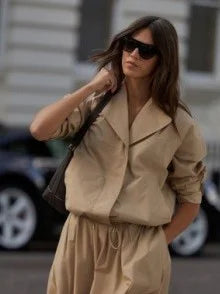 Tan boxy blouson jacket with a wide, soft collar and gathered drawstring waist.