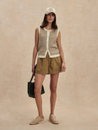 Sleeveless knit top featuring a cream and brown small checkerboard pattern and front buttons.