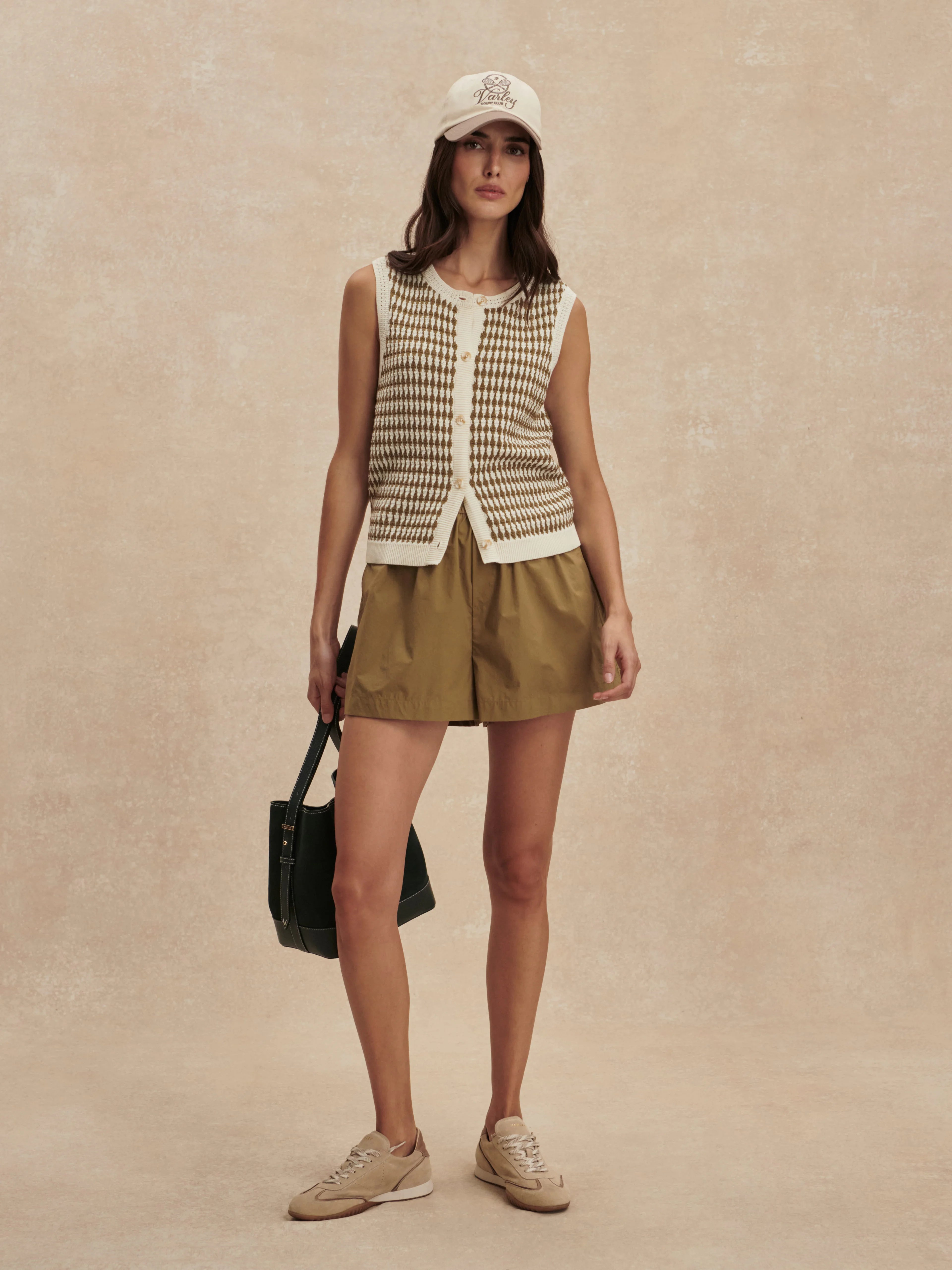 Sleeveless knit top featuring a cream and brown small checkerboard pattern and front buttons.