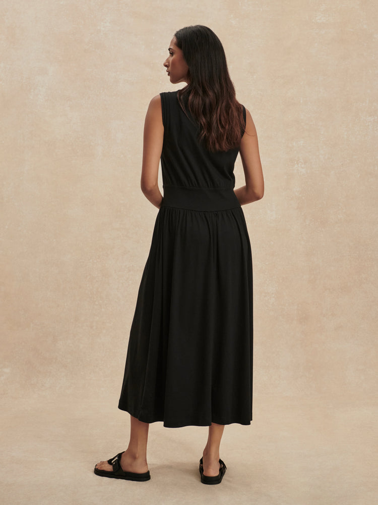 Black sleeveless maxi dress with an elasticated waist and flowing skirt, shown from the back.