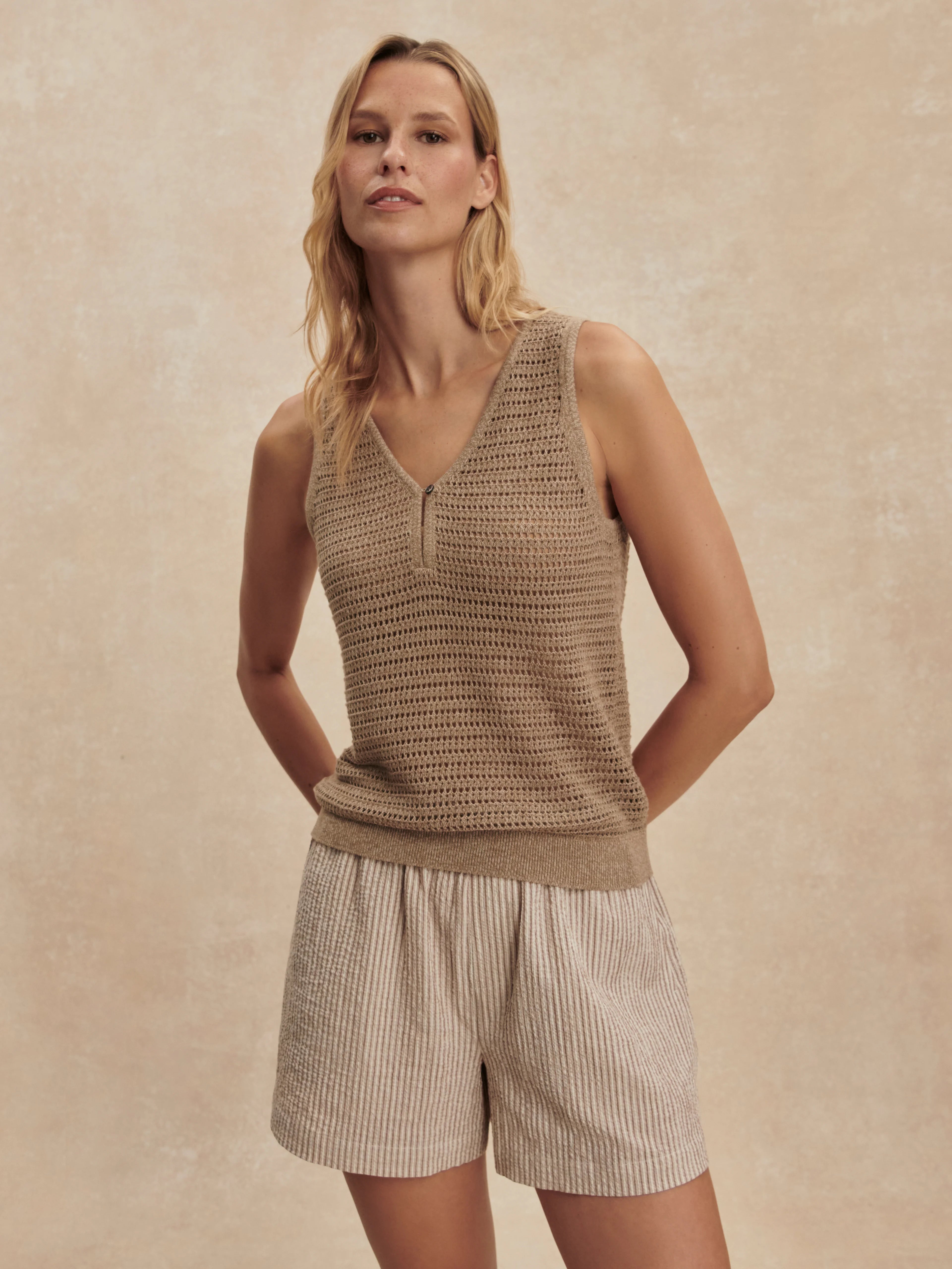 Tan open-knit V-neck tank with a single button henley placket.