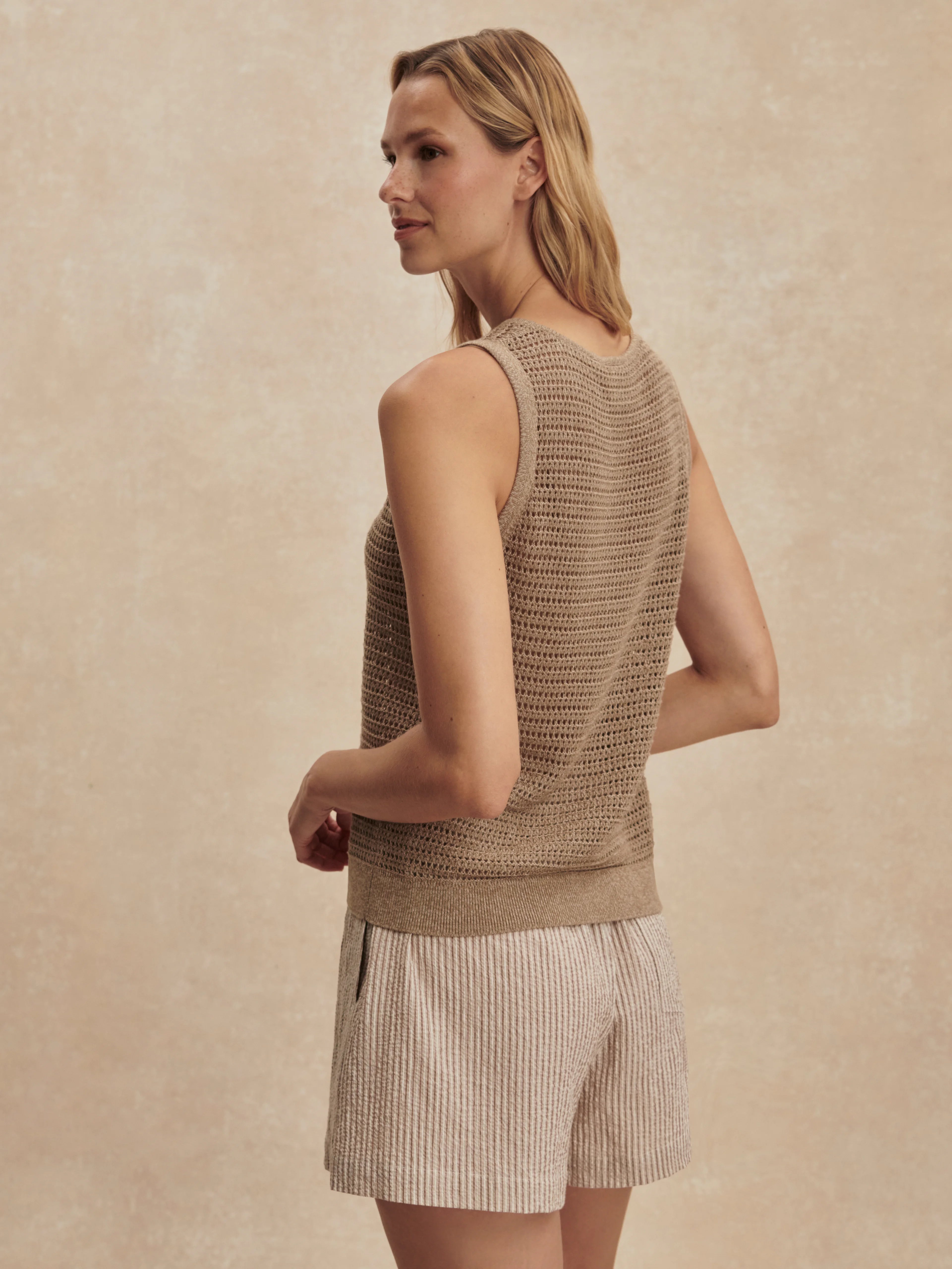 Tan open-knit tank top, sleeveless, with a ribbed hem.