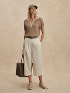 Light brown ribbed knit polo shirt with short sleeves and a beige contrasting collar and button placket.