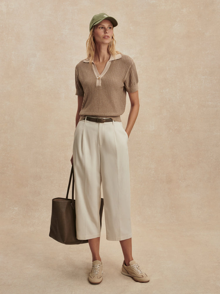 Light brown ribbed knit polo shirt with short sleeves and a beige contrasting collar and button placket.